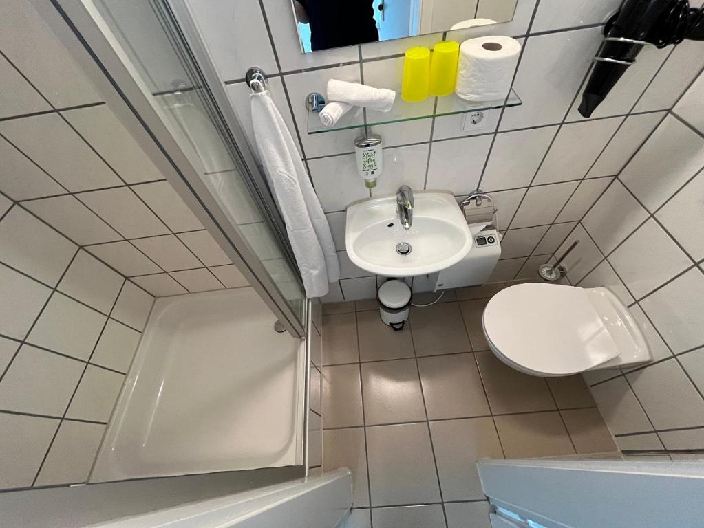 a small bathroom with a sink and a toilet at Pension am Park in Rust