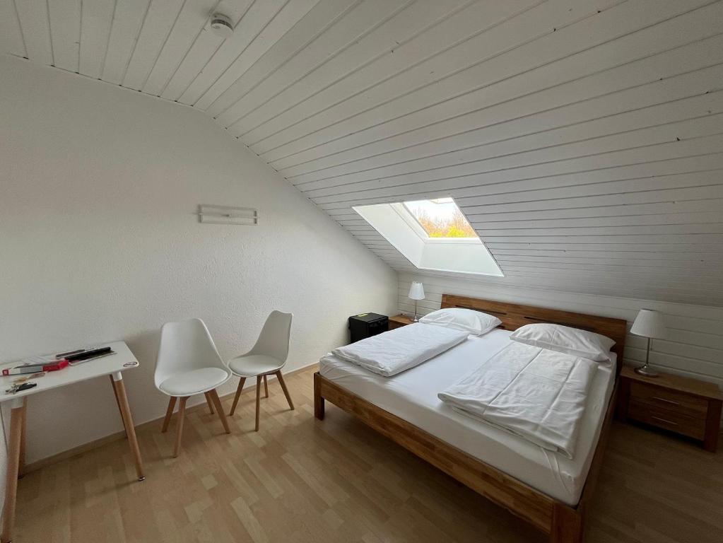 a bedroom with a bed and a table and chairs at Pension am Park in Rust