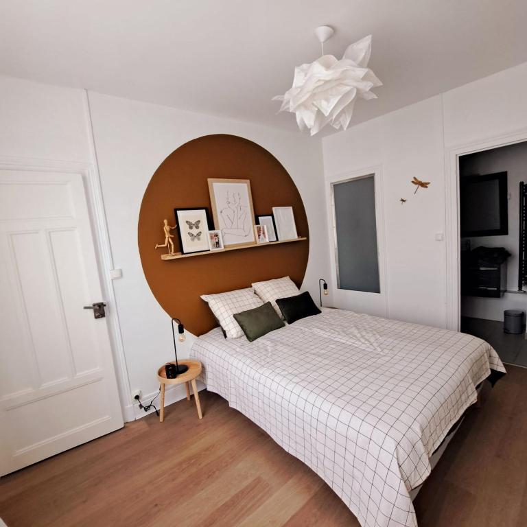 une chambre avec un grand lit avec une tête de lit en bois dans l'établissement L'arrière cour, à Dijon