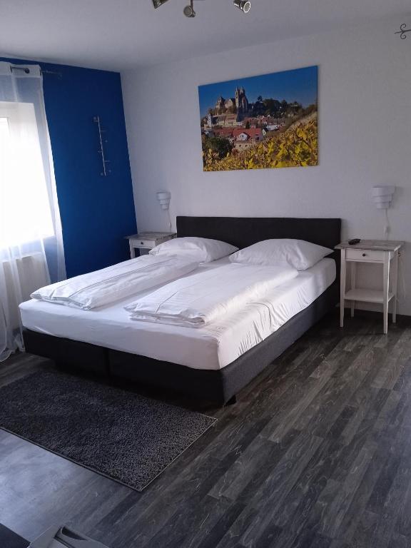 a large bed in a bedroom with two night stands at Pension am Park in Rust