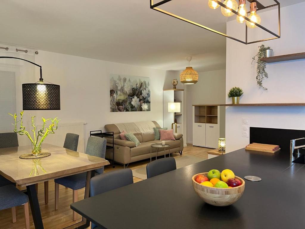 un salon avec une table avec un bol de fruits dessus dans l'établissement Le Passage - Disneyland Paris - Louez L'Esprit Libre !, à Chessy