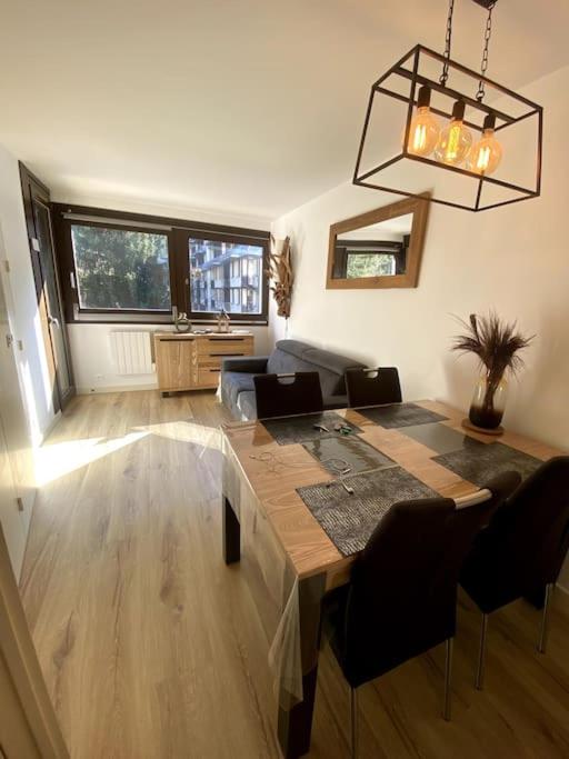 a living room with a table and a couch at Appt Cosy au centre Chamonix in Chamonix