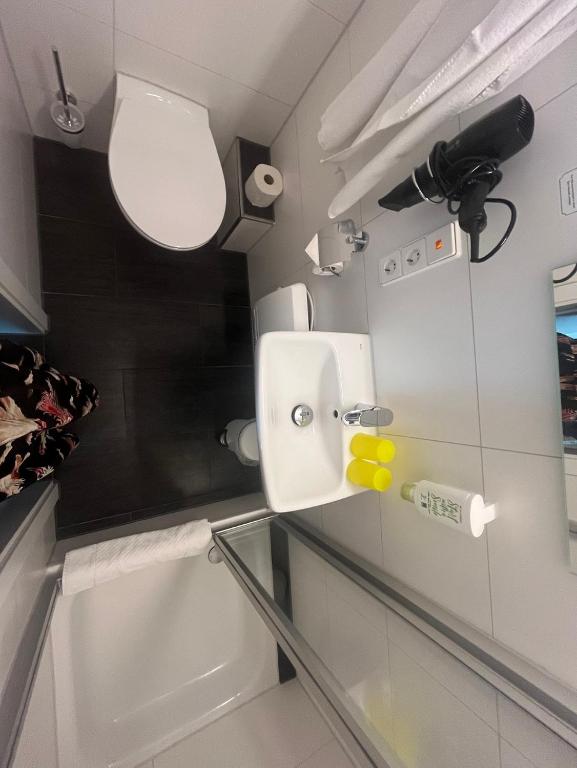 a bathroom with a toilet and a glass counter at Pension am Park in Rust