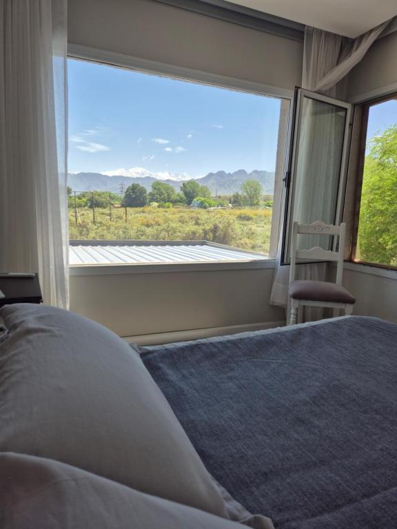 a bedroom with a bed and a large window at Casa de Montaña in Ciudad Lujan de Cuyo