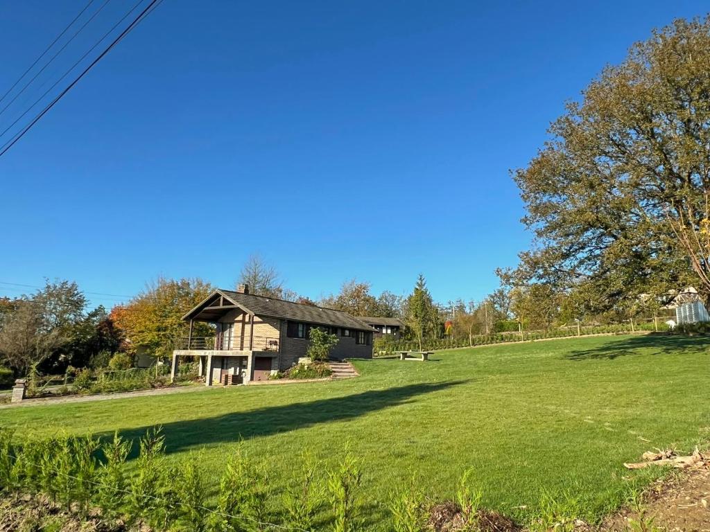 a house on a grassy field with a house at Pré Vert in Durbuy