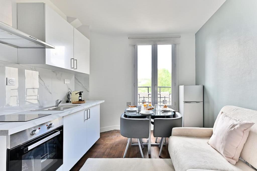 - une cuisine blanche avec une table et un canapé dans l'établissement Peaceful Apartment next to Paris Gagny - II, à Gagny