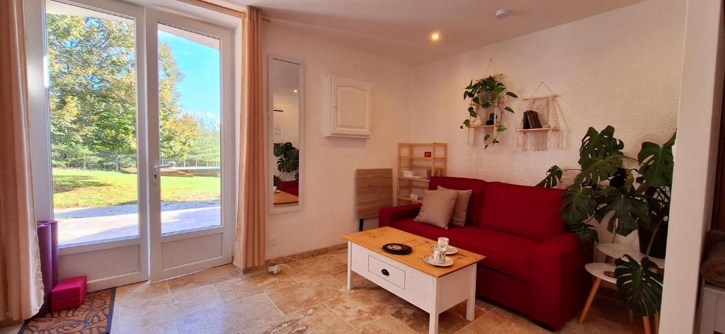 Montignac-de-LauzunにあるLes Gites Sur La Colline - 28 m2 one bedroom gite with shared poolの赤いソファとテーブルのあるリビングルーム