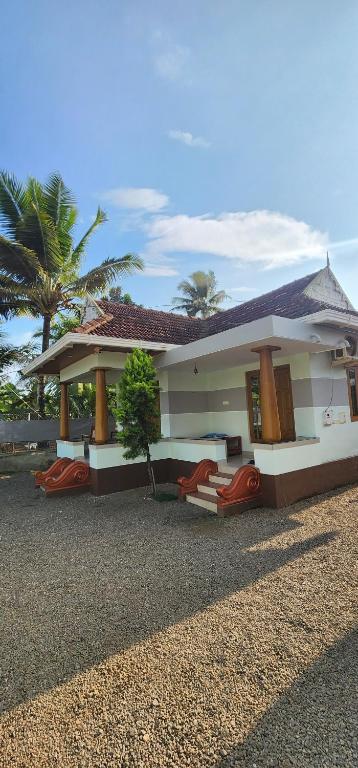a house with red chairs in front of it at Punerjeni Homes in Alleppey