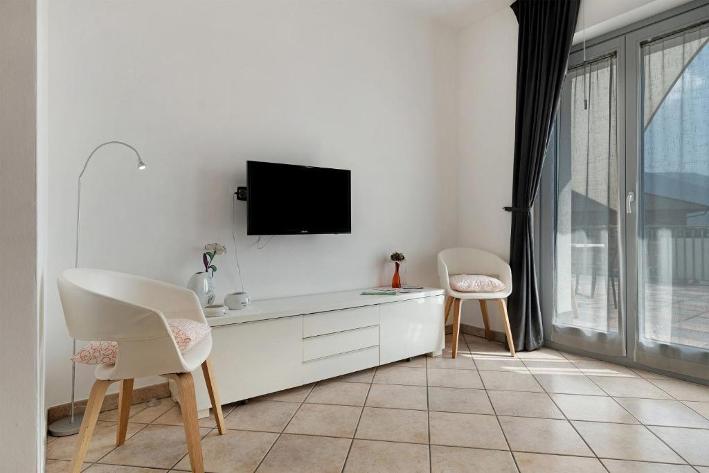 a white room with two chairs and a tv at Ciclamino Superior Otto in San Lorenzo in Banale