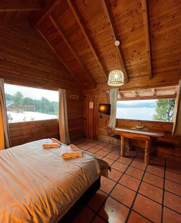 a bedroom with a bed and a desk in a cabin at Costa Traful in Villa Traful