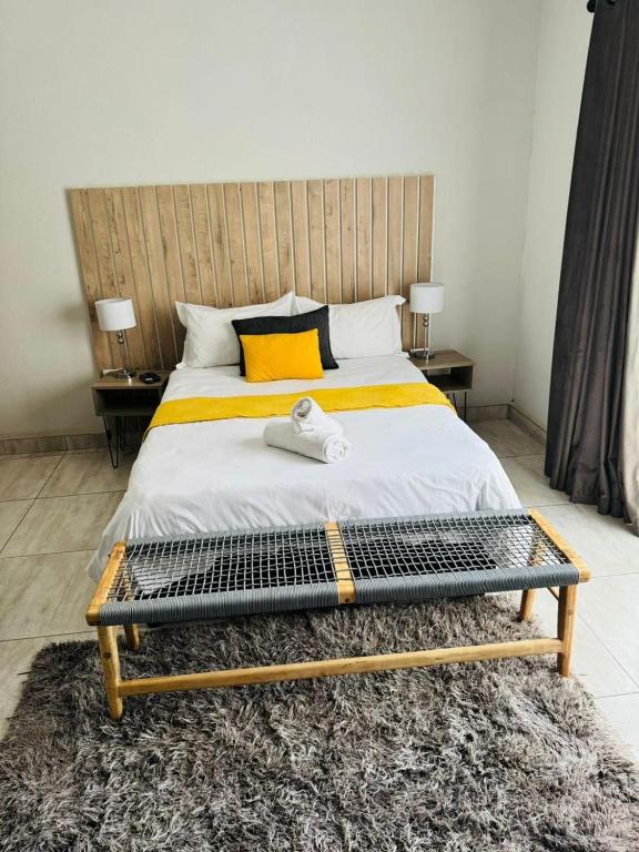 a bedroom with a bed with a wooden headboard at Kioma Guest House in Mokopane