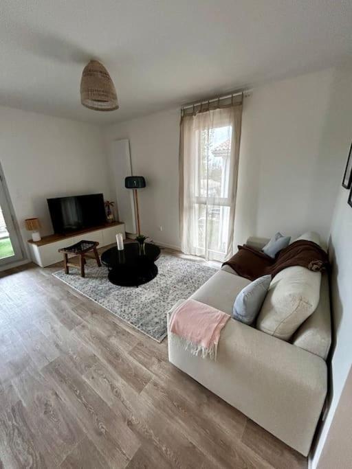 un salon avec un canapé et une télévision dans l'établissement Petit havre de paix !, à Carcans