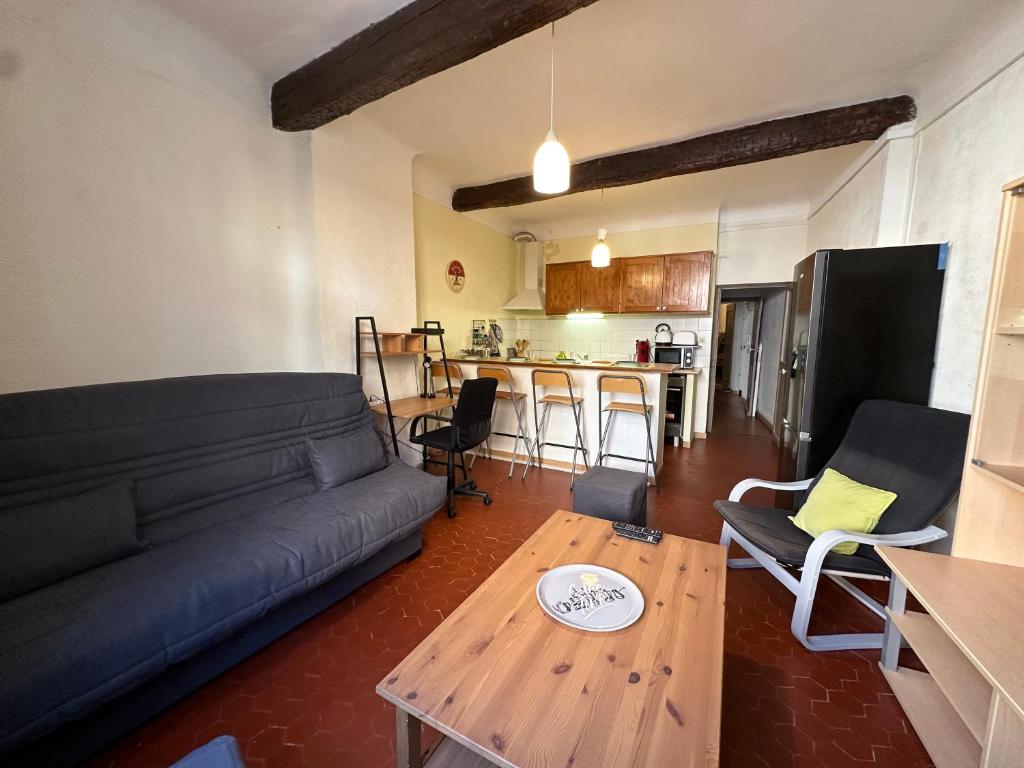 un salon avec un canapé et une table dans l'établissement Chez Florence - Appartement T2 d au cœur du centre ville historique - Proche Cardeurs et Mairie, à Aix-en-Provence