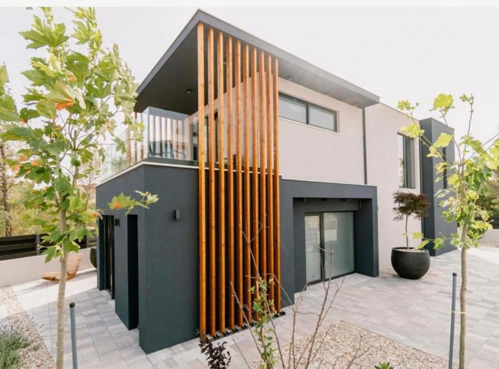 a modern house with wooden vertical lines on the facade at Luxury Contemporary Villa in Vodice with Pool, Sauna and Hot Tub in Vodice