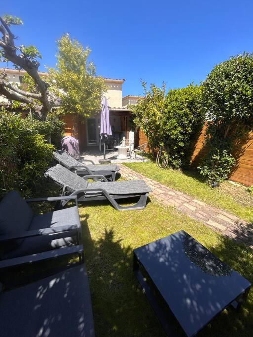 un groupe de chaises et de tables dans une cour dans l'établissement Maison bord de mer, à Poggio-Mezzana