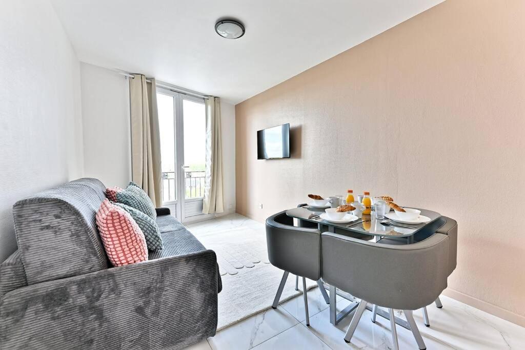 un salon avec un canapé et une table dans l'établissement Appartement moderne proche Paris - Gagny - III, à Gagny