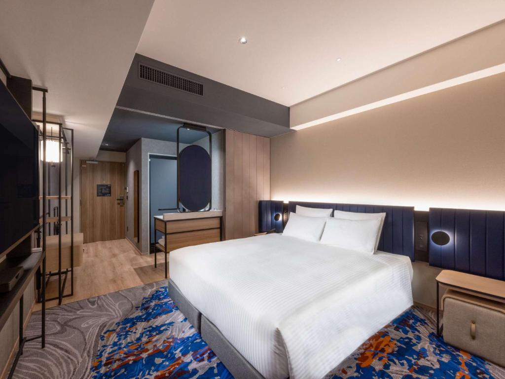 a bedroom with a large bed and a television at Novotel Nara in Nara