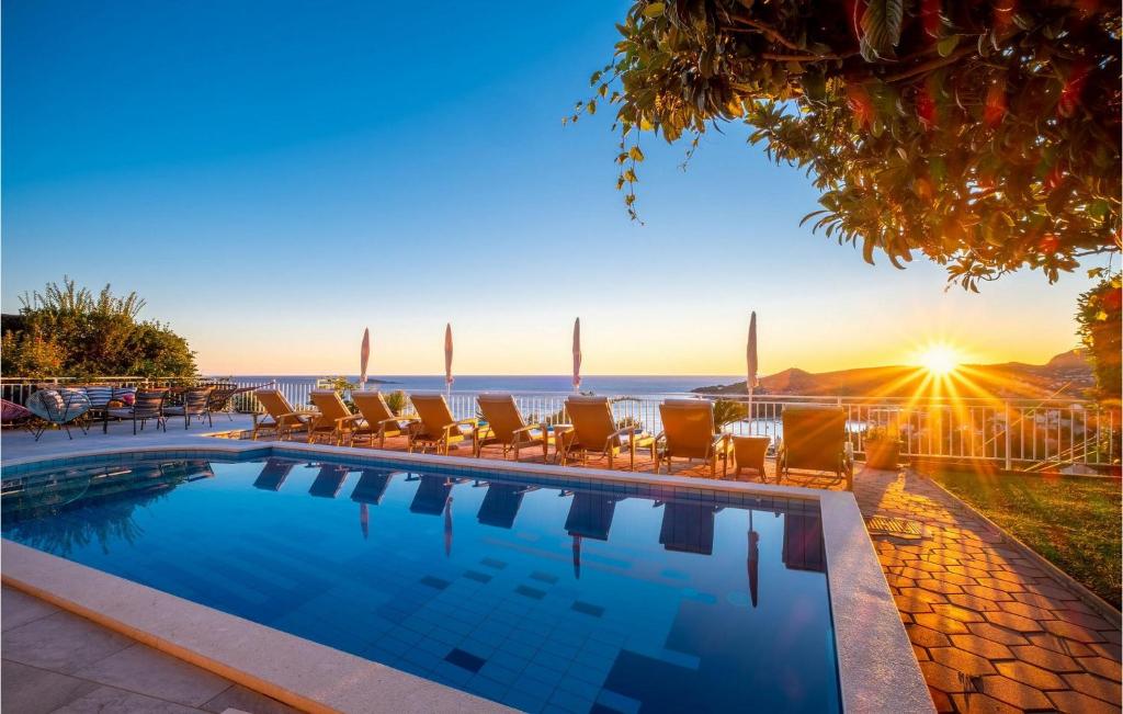 a pool with chairs and the ocean in the background at Villa Libertas in Mlini