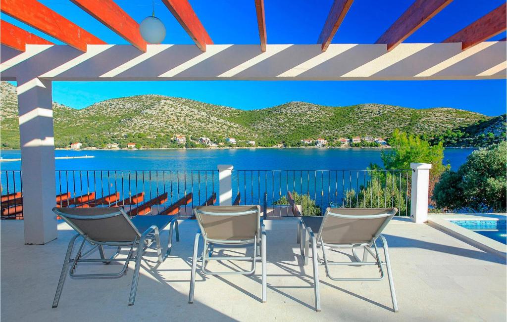 eine Terrasse mit Stühlen und einem Tisch mit Seeblick in der Unterkunft Villa Tapenade in Lastovo