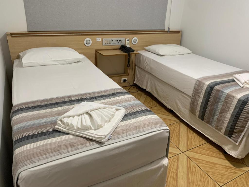 Postel nebo postele na pokoji v ubytování GoldMen Select Maringá