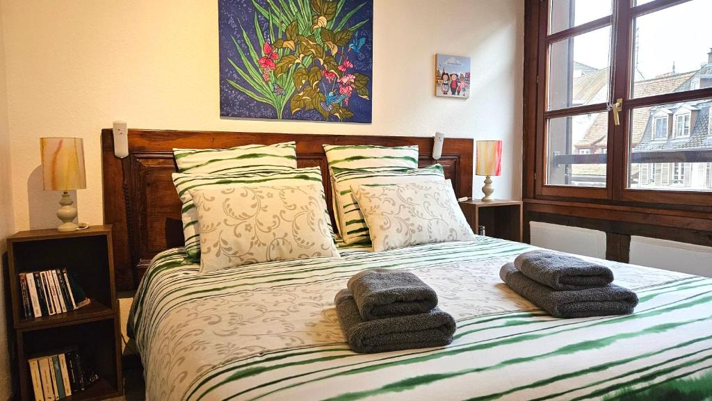 Hotel Les Berges de l'Ill, a bedroom with a bed with two towels on it at Les Berges de l'Ill in Strasbourg