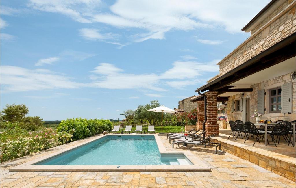 - une piscine avec des chaises et une table sur la terrasse dans l'établissement Villa Miramonti, à Sveti Lovreč Pazenatički