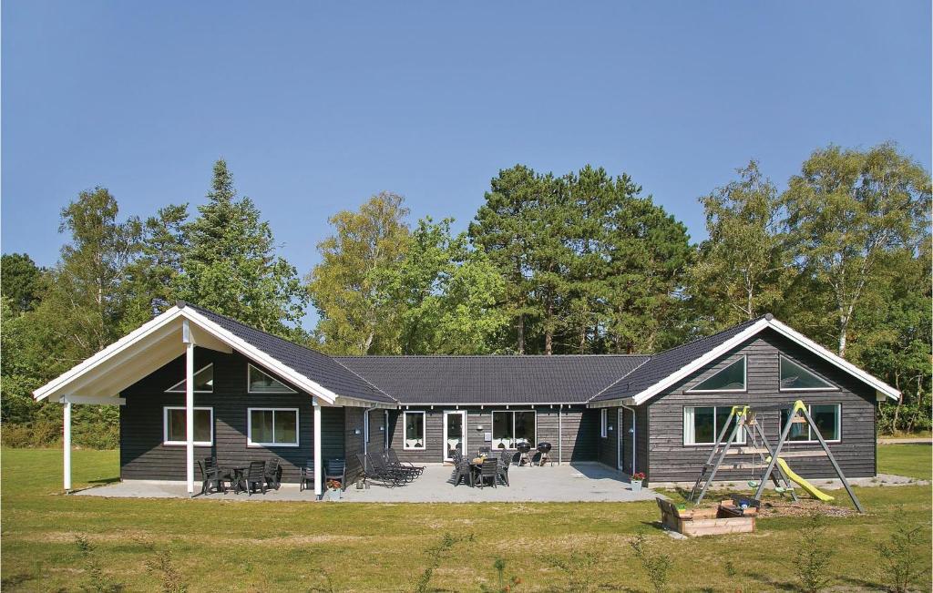 a log cabin with a porch and a playground at Eight-Bedroom Holiday Home Frederiksværk With A Room Hot Tub 05 in Melby