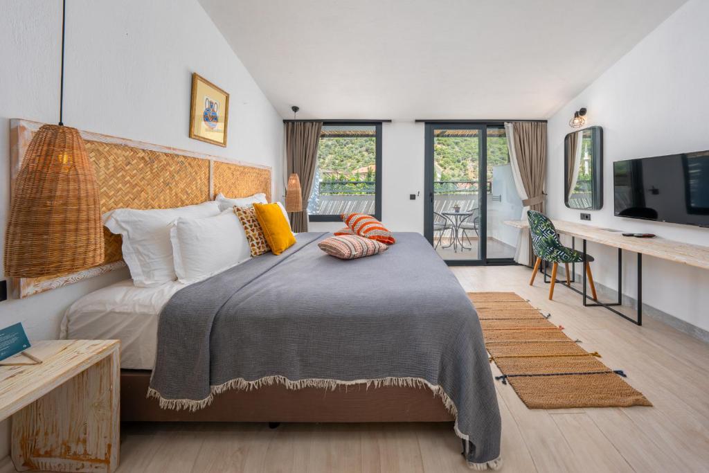 a bedroom with a bed and a desk with a television at Ölüdeniz Blu Luxury Unique Hotel - Adults-Only in Oludeniz