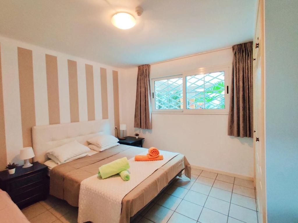 Un dormitorio con una cama con una toalla amarilla. en Rocas del Mar 138, en Costa del Silencio