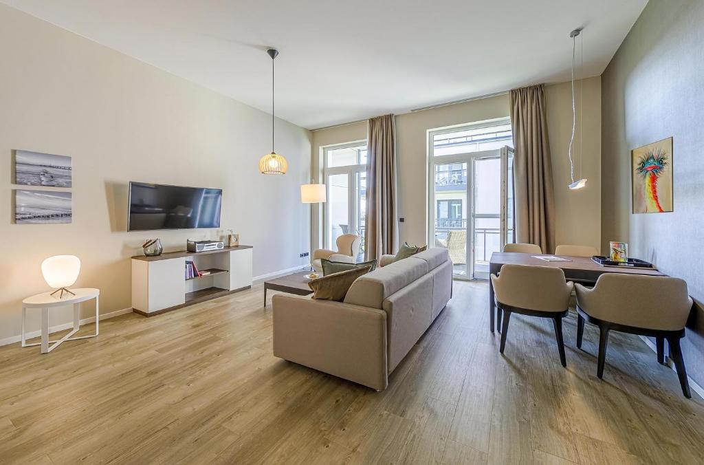 un soggiorno con un divano e un tavolo di Modernes Ferienapartment Ostseemöwe mit Westbalkon a Wustrow