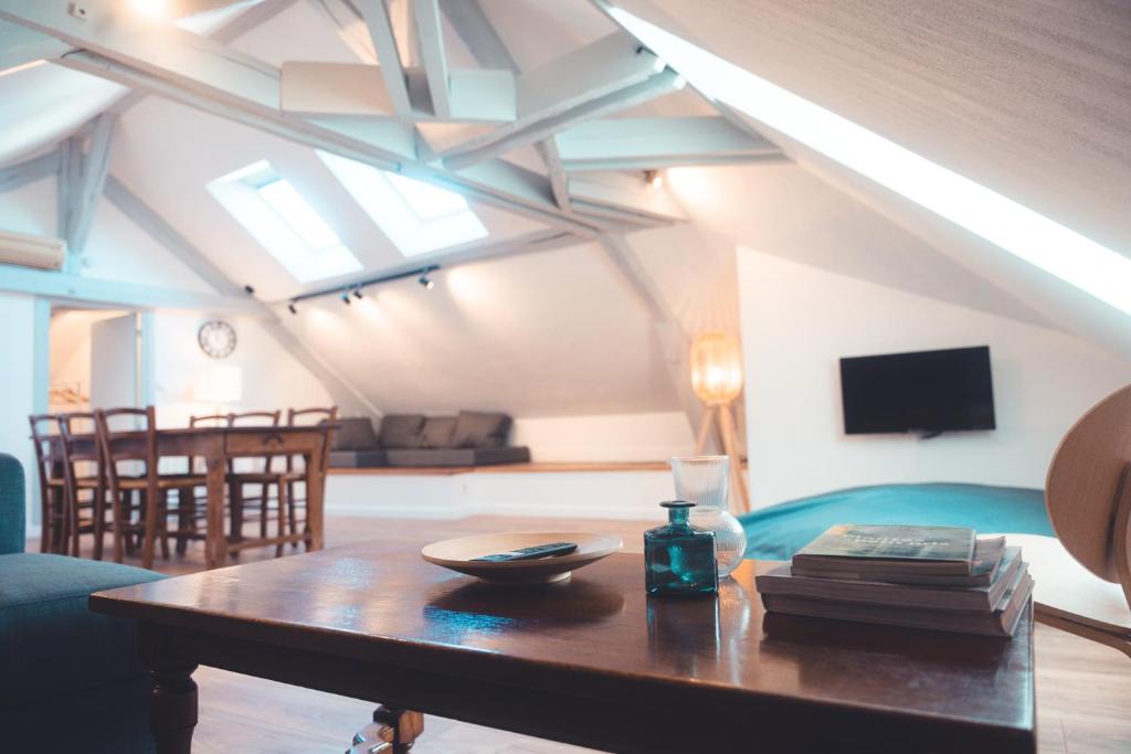 un salon avec une table et un canapé dans l'établissement Le Nid dAigle - Spacieux logement sous les toits, à Tours