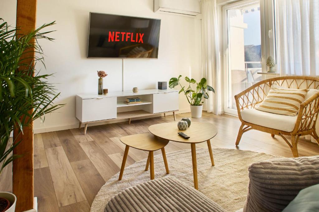a living room with a couch and a tv at Ajko Homes - Riverside Apartment I ruhige Lage I Balkon nähe Heidelberg in Edingen-Neckarhausen