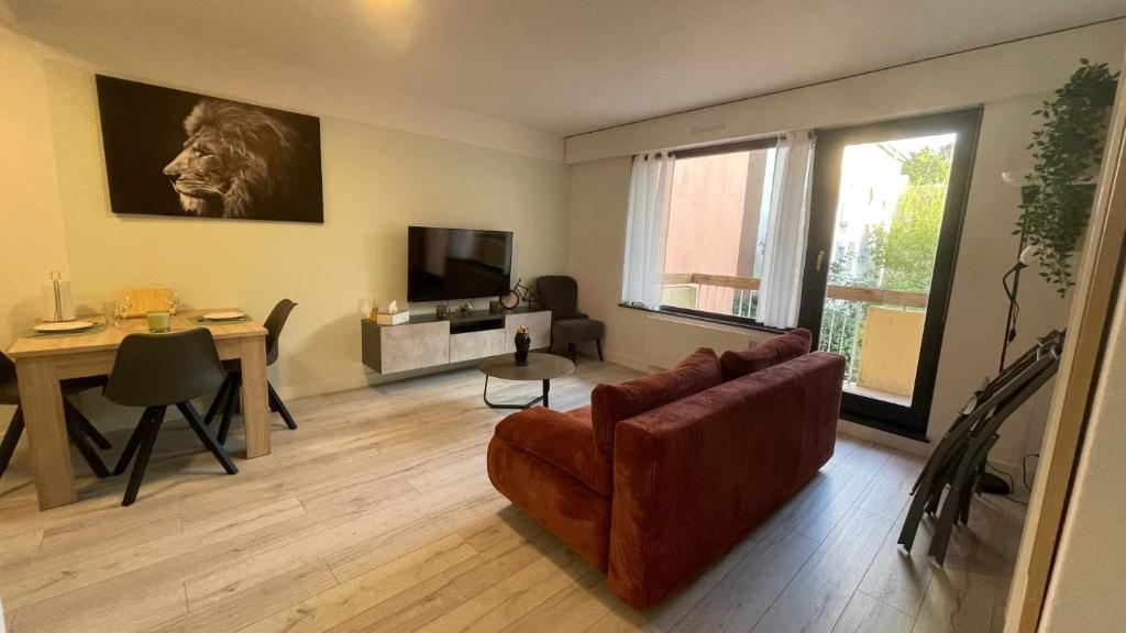 a living room with a couch and a table at Appartement confortable 4 personnes à 10 min de strasbourg - Parking inclus in Schiltigheim