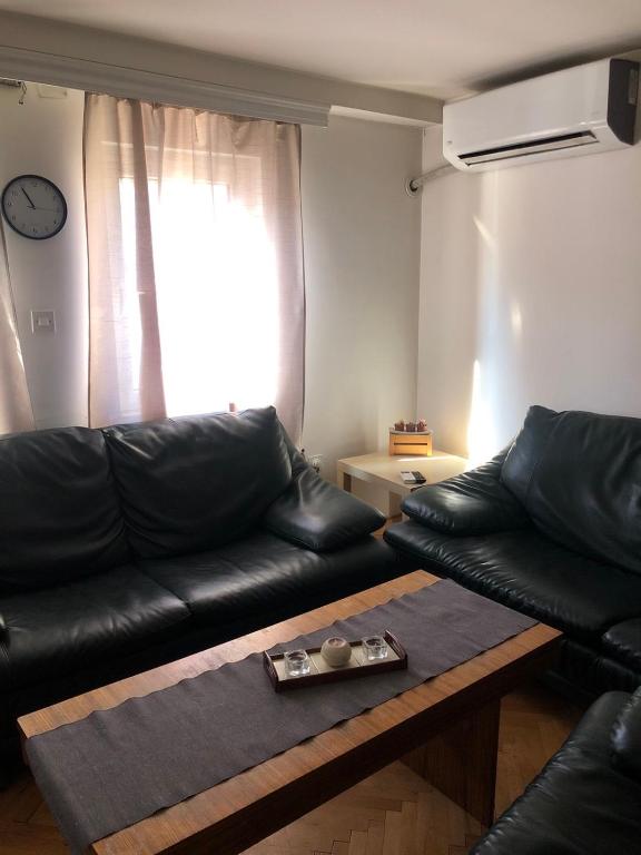 Kriva PalankaApartment KARADAK的客厅里有一张黑色皮沙发和一张桌子