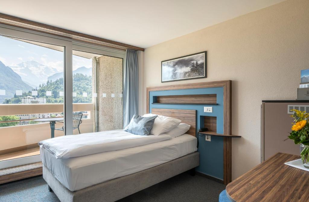 Postel nebo postele na pokoji v ubytování Hotel Metropole Interlaken