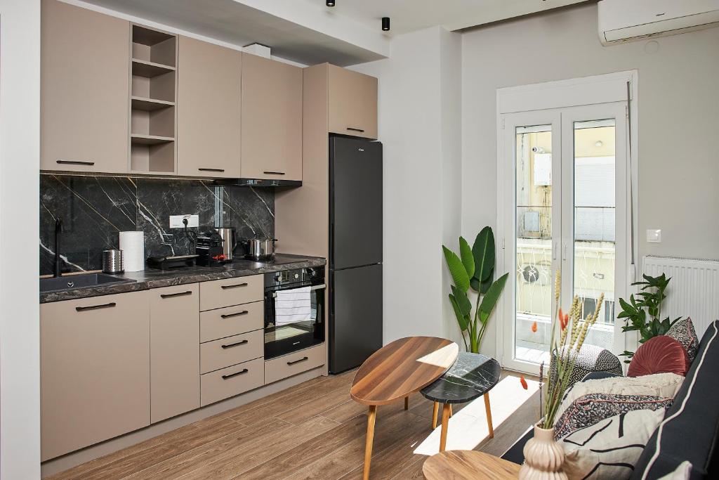 a kitchen with white cabinets and a living room at Dream Luxury Apartment in the City Center by BiNoBi! in Thessaloniki