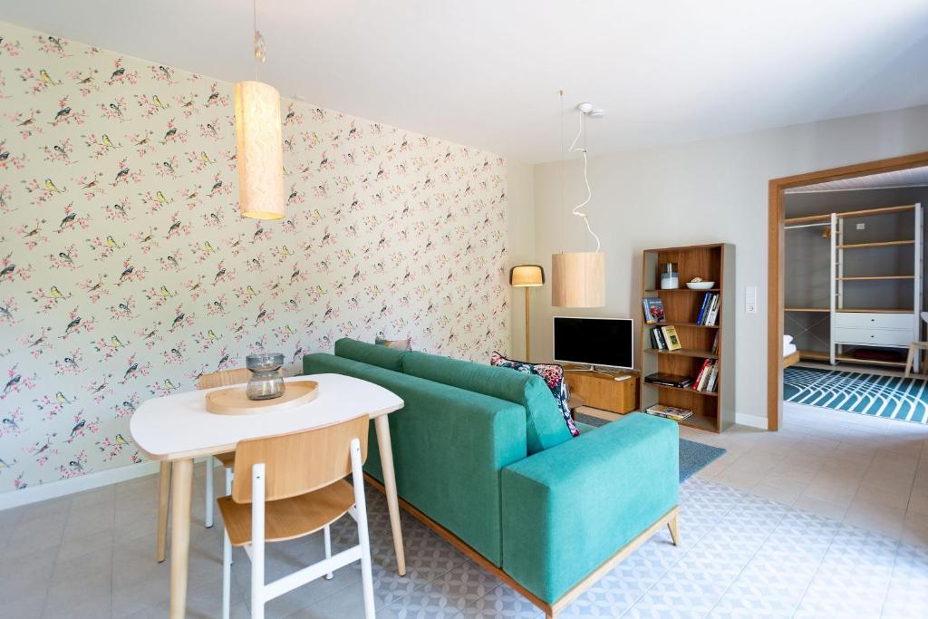 a living room with a green couch and a table at Haus Silvana, App 03 Bungalow in Zempin