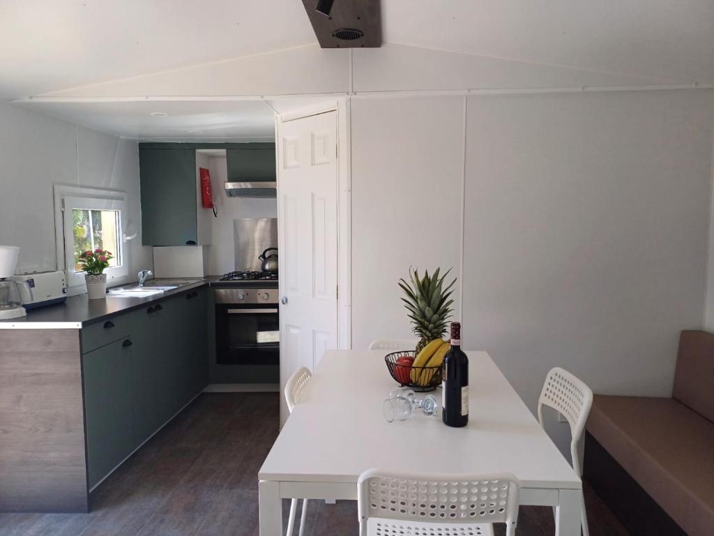 a small kitchen with a white table and chairs at Camping Tucan - Mobile Homes by Lifestyle Holidays in Lloret de Mar