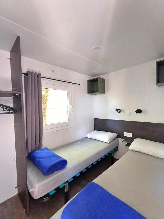 a small room with two beds and a window at Camping Tucan - Mobile Homes by Lifestyle Holidays in Lloret de Mar