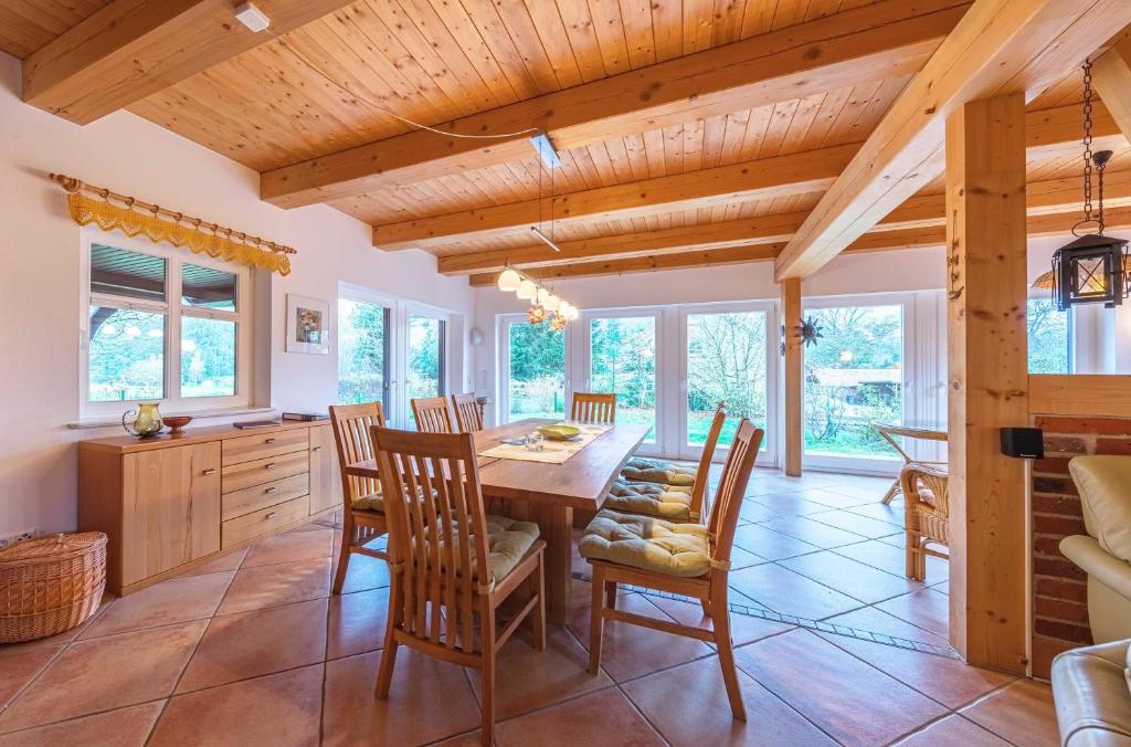una sala da pranzo con tavolo e sedie in legno di Havelquelle mit Sauna und Garten a Kratzeburg