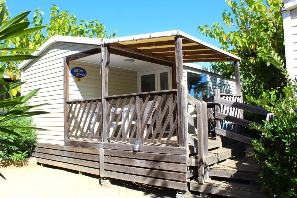 a small house with a porch and a deck at Camping Tucan - Mobile Homes by Lifestyle Holidays in Lloret de Mar