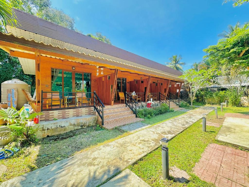 Casa de madera con porche y patio en Aow Thai Homestay, en Ban Hin Dam
