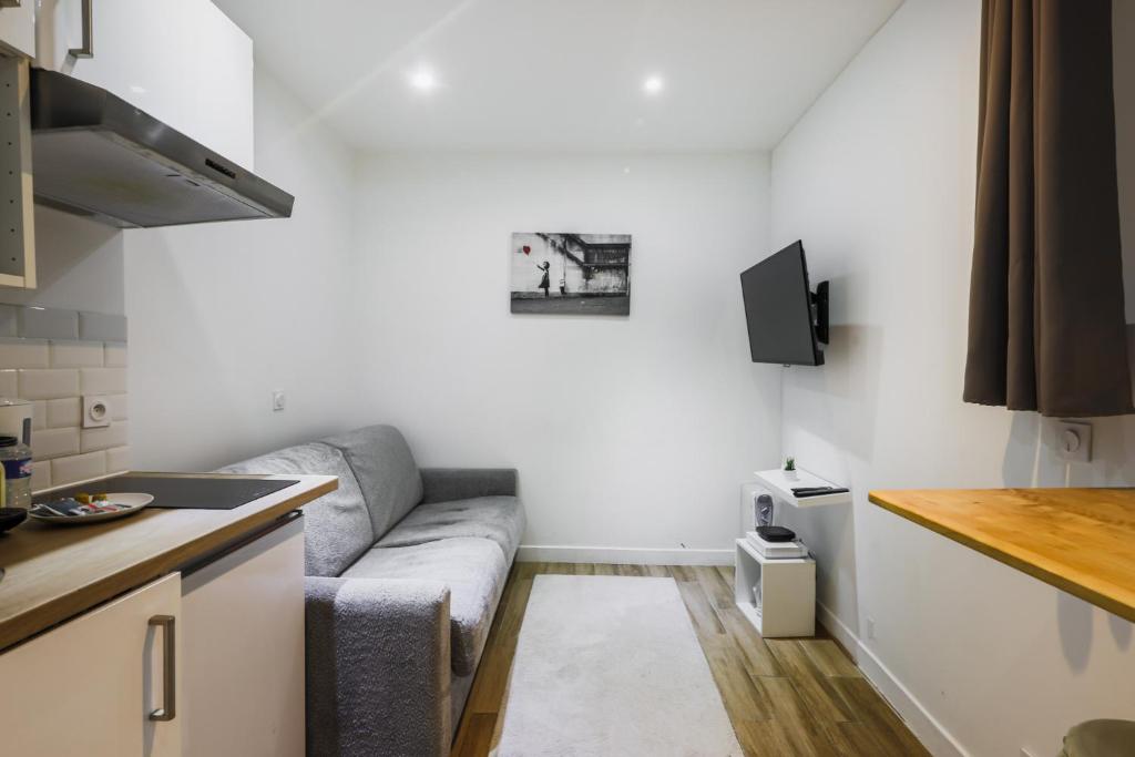 un salon avec un canapé dans une cuisine dans l'établissement Cosy studio - 2P - Sentier, à Paris