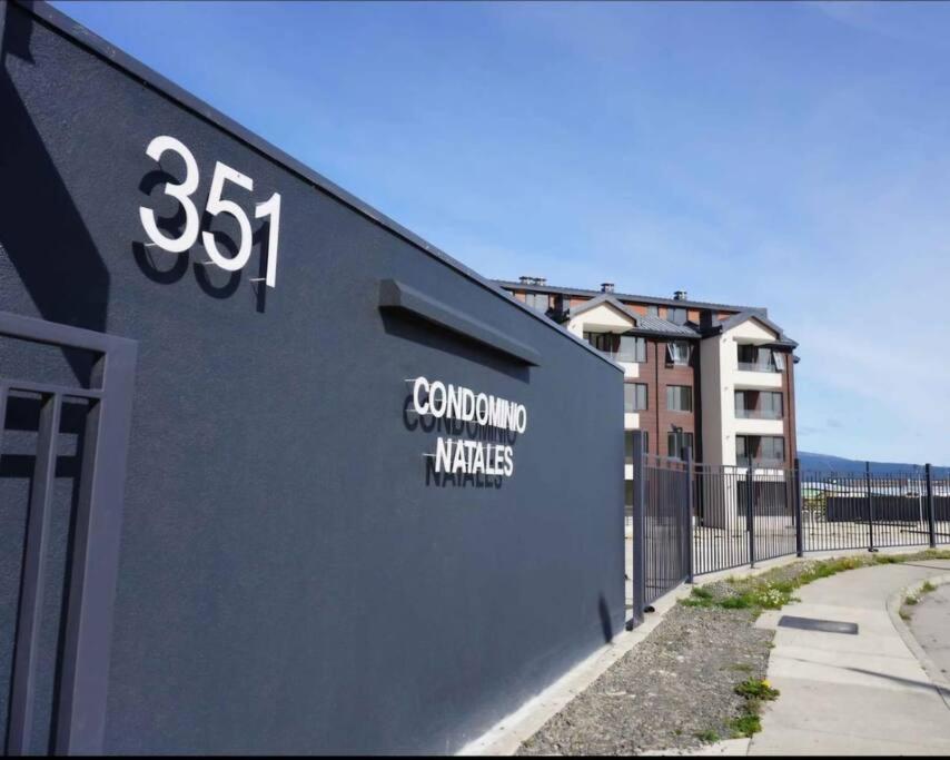 Un edificio con un cartel al costado. en Depto Mirador del Fiordo, en Puerto Natales