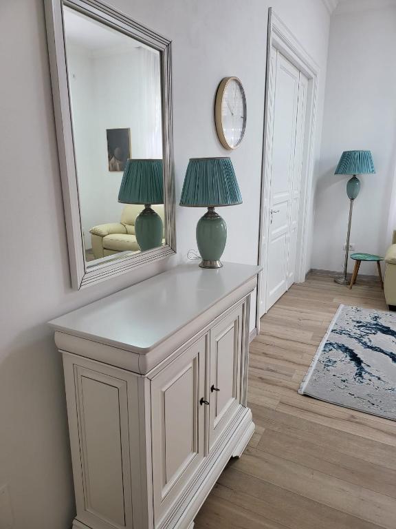 Zimmer mit einem Spiegel und einem Tisch mit einer Lampe in der Unterkunft Guest House Eleni in Balş