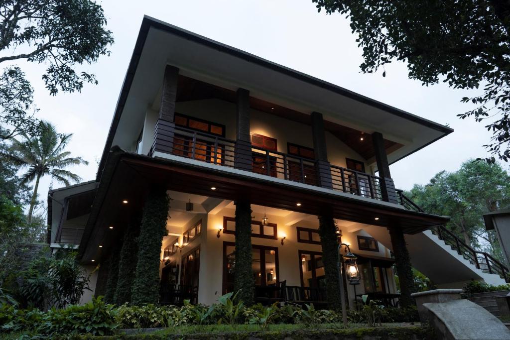 a house with a lit up facade at Carmelia Haven Resort Thekkady in Idukki
