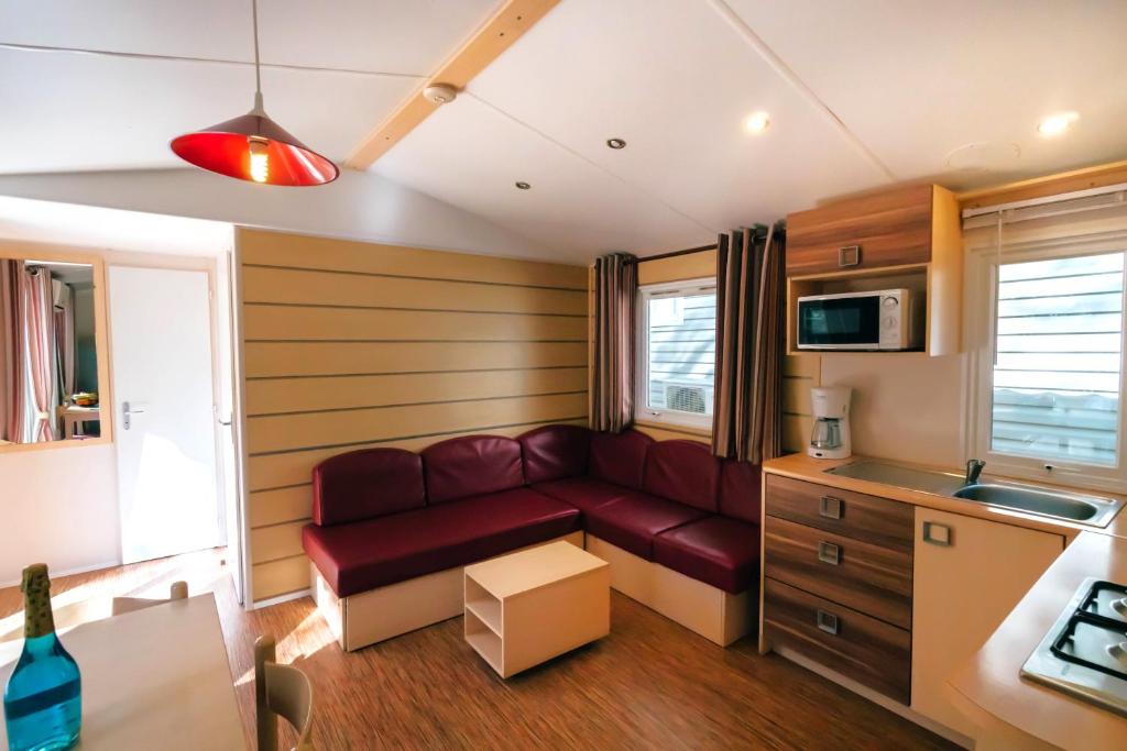 a living room with a red couch in a kitchen at Camping Tucan - Mobile Homes by Lifestyle Holidays in Lloret de Mar