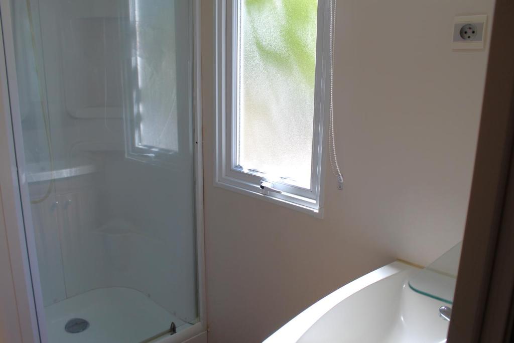 a bathroom with a shower and a tub and a window at Camping Tucan - Mobile Homes by Lifestyle Holidays in Lloret de Mar