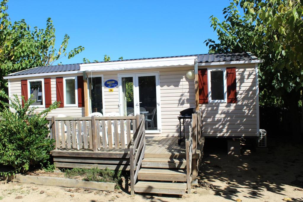 a white tiny house with a wooden porch at Camping Tucan - Mobile Homes by Lifestyle Holidays in Lloret de Mar