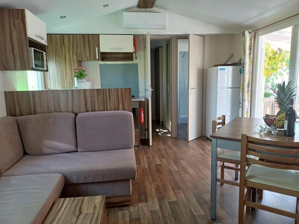 a living room and kitchen with a couch and a table at Camping Tucan - Mobile Homes by Lifestyle Holidays in Lloret de Mar